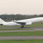 White commercial airplane taking off from runway