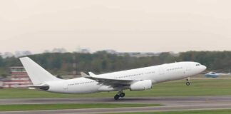 White commercial airplane taking off from runway