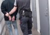 Abolish ICE Pledge Meets Brutal Reality Security officer escorts handcuffed person down hallway