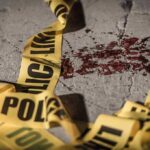 Crime scene tape near blood on pavement