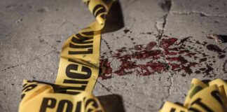 Crime scene tape near blood on pavement