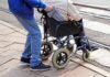Charity Scam? AG Targets ‘Veterans’ Group Caregiver pushing person in wheelchair over curb