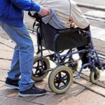 Charity Scam? AG Targets ‘Veterans’ Group Caregiver pushing person in wheelchair over curb