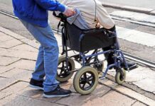 Charity Scam? AG Targets ‘Veterans’ Group Caregiver pushing person in wheelchair over curb