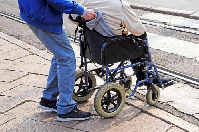 Caregiver pushing person in wheelchair over curb