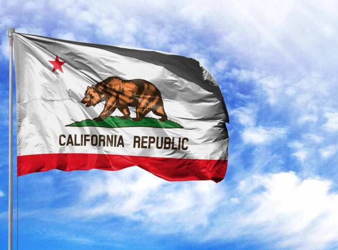 shutterstock_1209468139-1 California state flag waving against a blue sky