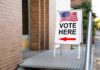 Trump’s Election Security Push Hits Court Sidewalk sign with American flag directing to a polling place