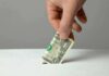 Donor Dollars Buy Tacos And Liquor? Hand inserting a folded dollar bill into a small slot
