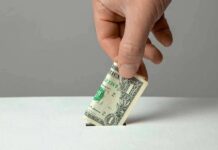 Donor Dollars Buy Tacos And Liquor? Hand inserting a folded dollar bill into a small slot