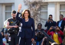 woman in navy suit waving at outdoor event