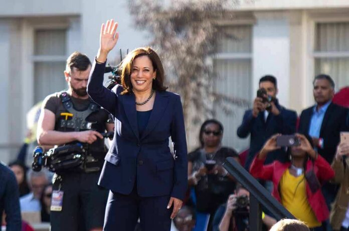 shutterstock_1296858898 woman in navy suit waving at outdoor event