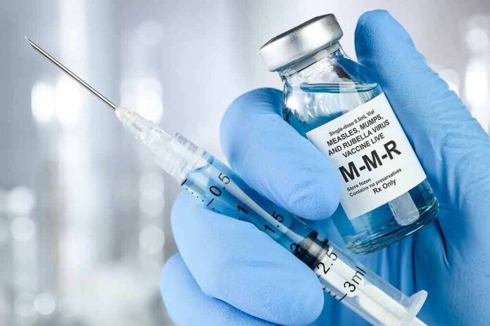 shutterstock_1449408860 Gloved hands holding a vaccine vial and syringe