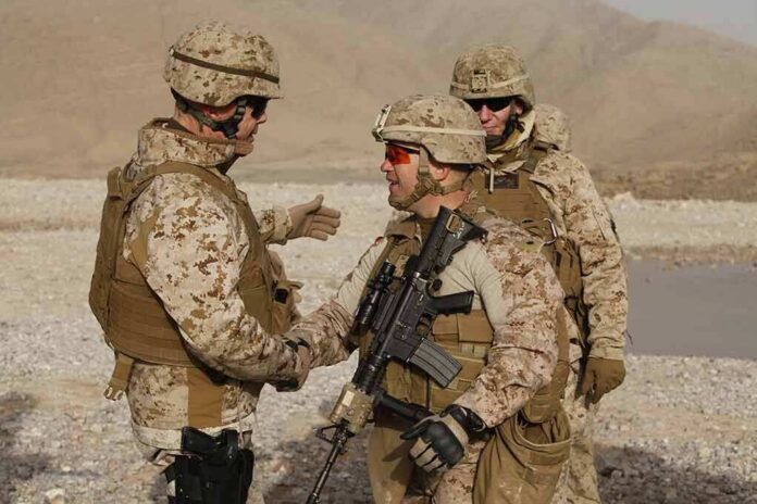 Soldiers in desert uniforms shake hands outdoors