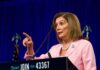 woman in pink suit speaking at a podium