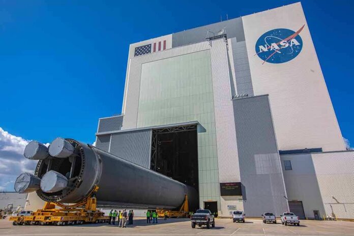 shutterstock_1521722225 Rocket stage moved on transporter outside large NASA assembly building