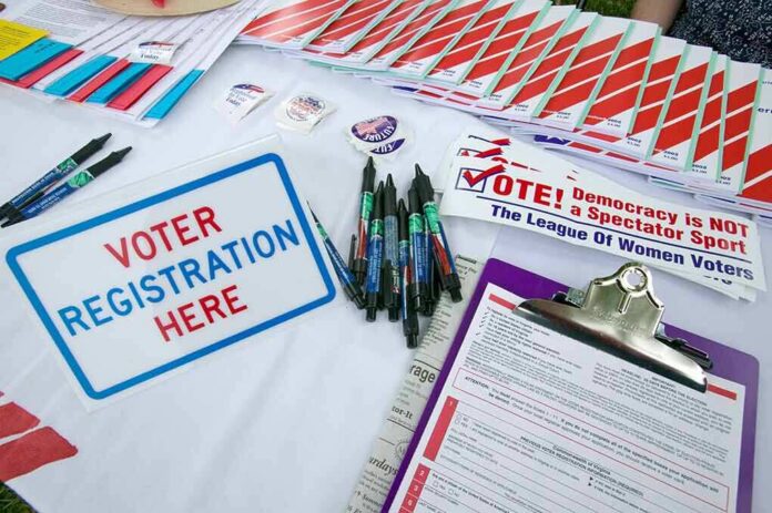 Voter registration table with forms, pens, and informational materials