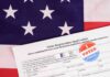 Voter registration form with I Voted sticker on American flag