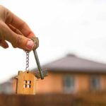 Sticker Shock: Manhattan Rents Go Nuclear Hand holding house key with wooden house keychain