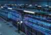 County’s Tax Windfall Faces A New Threat Technician with laptop in a large data center aisle