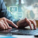 Hands typing on a laptop with AI chat icons