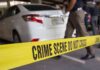 Parking Lot Horror Exposes Giant Failure Yellow crime scene tape in front of a white car with investigators nearby