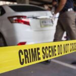 Parking Lot Horror Exposes Giant Failure Yellow crime scene tape in front of a white car with investigators nearby