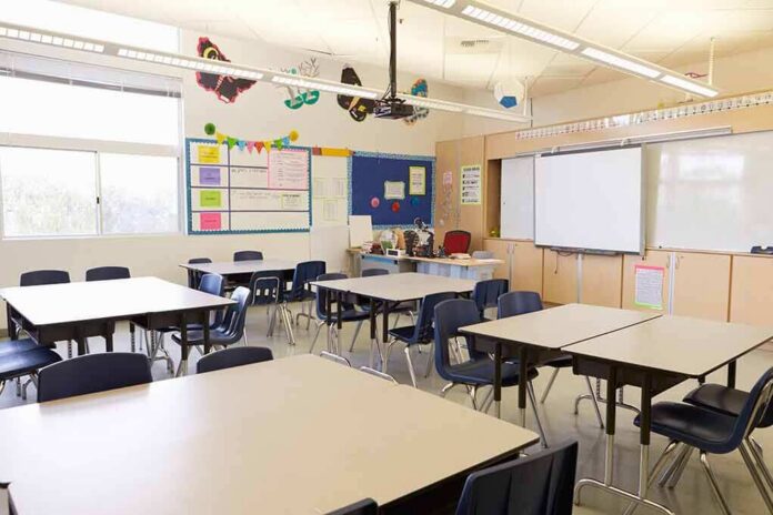shutterstock_388578202 Empty classroom with tables, chairs, and a whiteboard