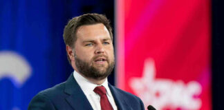 Man in suit speaking at a podium with microphone