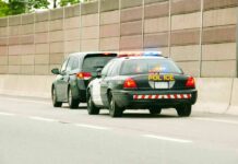 Police car with flashing lights stops a minivan on highway