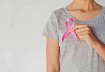 Breast Cancer Fight Becomes Political Brawl Person holding a pink ribbon on a gray shirt