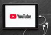 Tablet displaying YouTube logo with wired earphones