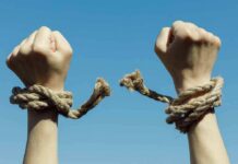 Oscar Rebel Cuffed During UN Chaos Hands breaking free from rope bindings against a clear blue sky