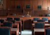 Discipline Looms After Explosive Hearing Empty courtroom with wooden benches and judge's bench