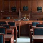 Discipline Looms After Explosive Hearing Empty courtroom with wooden benches and judge's bench