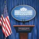 Judge Slaps Trump’s Media Blacklist White House press briefing podium and US flag