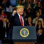 Unlikely Alliance: Trump–Schiff Woo Hollywood man speaking at a podium during a rally