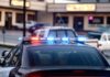Police car with flashing red and blue lights in a parking lot