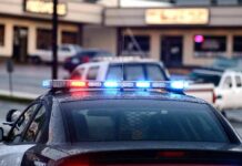 Police car with flashing red and blue lights in a parking lot