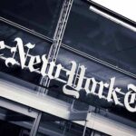NYT Exec Gunned Down The New York Times sign on a glass building facade