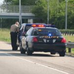 Highway Stop Exposes Gold Shakedown Police officer conducting a traffic stop on a highway