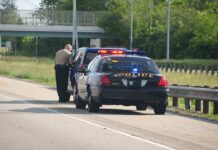 Highway Stop Exposes Gold Shakedown Police officer conducting a traffic stop on a highway