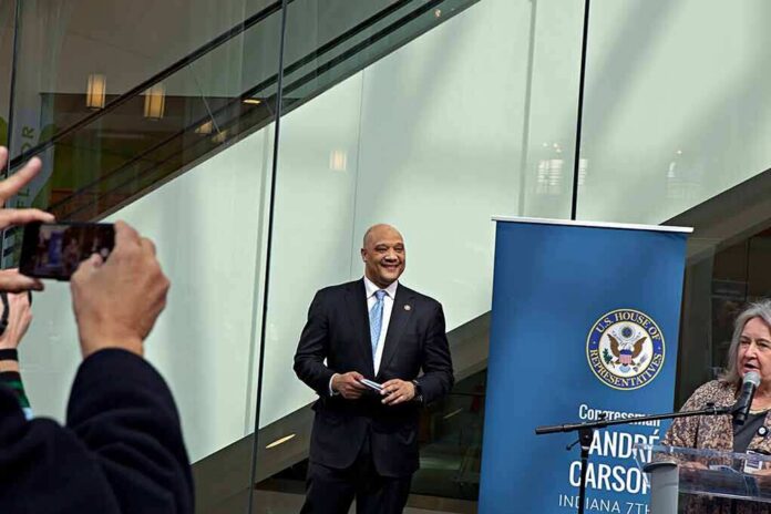 Man in a suit at a public event near a blue banner