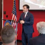 Communist Takeover Claim Ignites GOP Blitz Speaker in a navy suit addressing an audience at a podium