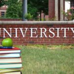 China Cash Trail Snags Elite Campuses Stack of books with apple in front of university sign