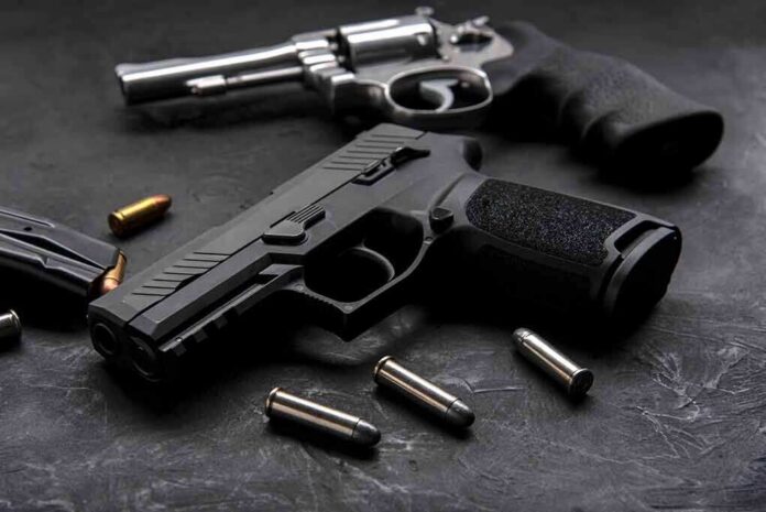 Handgun and revolver with scattered bullets on dark surface