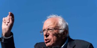 Bernie Sanders speaking at a podium outdoors