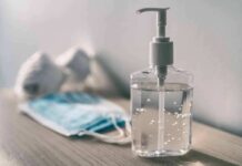Pandemic Loan Purge Stuns Borrowers Hand sanitizer bottle beside face masks on a table