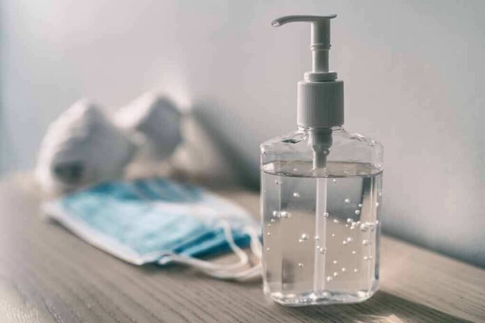 Hand sanitizer bottle beside face masks on a table