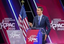Speaker in suit at CPAC podium on stage
