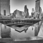 A memorial water feature surrounded by tall buildings in a city